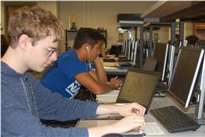 Two male students working at computer screens 